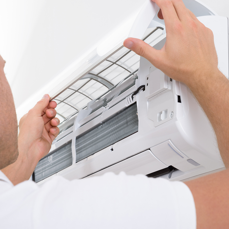 Technician servicing a wall mounted air conditioner